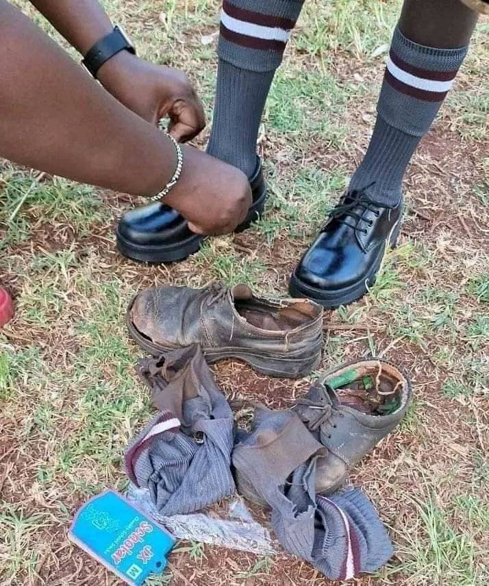 A school child getting a brand new pair of shoes put onto their feet with their old shoes on the floor next to them