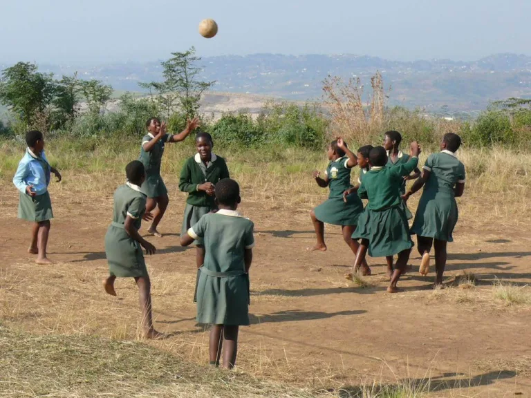 A group of young girls in school uniforms playing with a ball