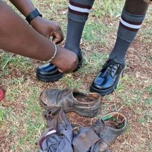 School boy getting a new pair of shoes with his old shoes next to his feet