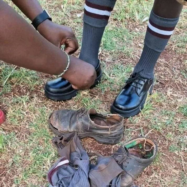 School boy getting a new pair of shoes with his old shoes next to his feet